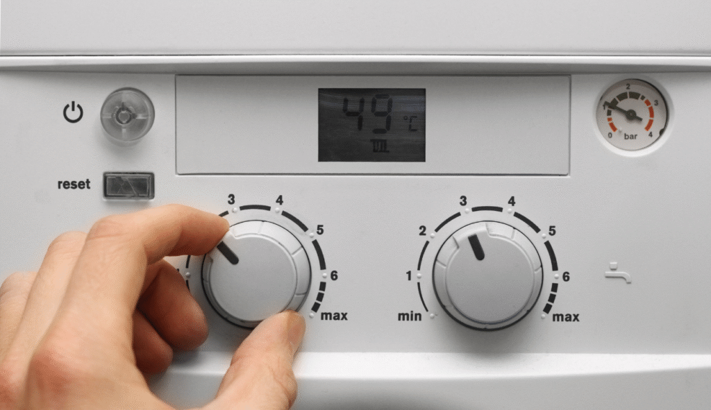 A person adjusting the dials on a combi boiler
